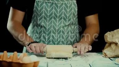 面包师用<strong>擀面杖</strong>在<strong>厨房</strong>的桌子上准备新鲜 人在一个光滑的表面上形成面团。 烹饪意大利面，sp